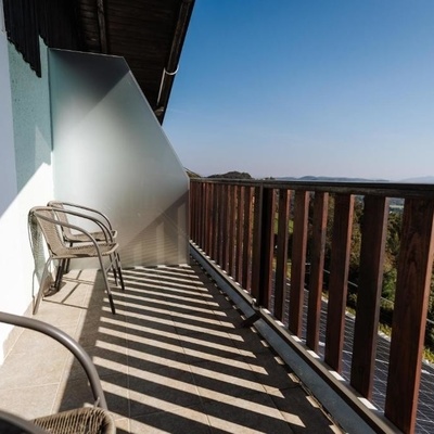 The balcony is furnished with chairs and a small table.