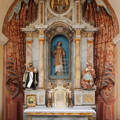 Oltar v stranski kapeli je posvečen sv. Lovrencu, ob njem sta kipa sv. Florjana in sv. Lenarta.