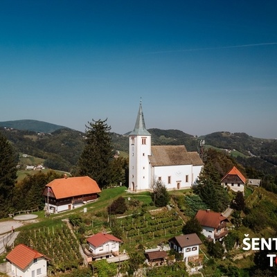 Cerkev sv. Uršule stoji na vrhu hriba, ki ga pokrivajo zidanice in vinogradi.