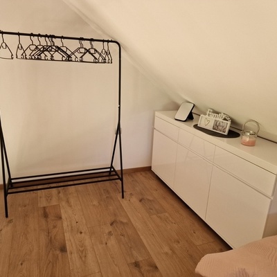 Spalnica v mansardi ima garderobni kotiček.