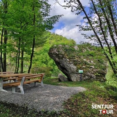 A table with benches is set up next to the megalith.
